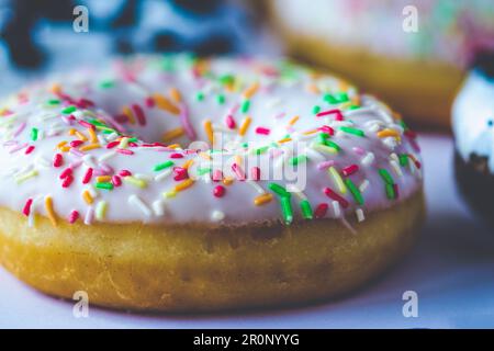 Nahaufnahme auf Ring Donut mit weißer Glasur und bunten Hunderten und Tausenden Stockfoto