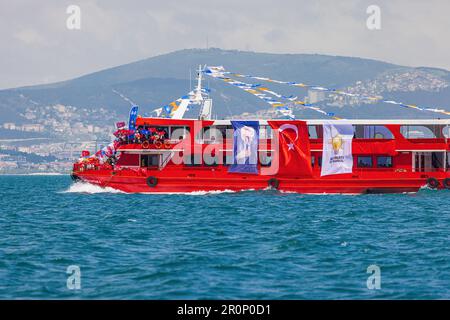 ISTANBUL, TÜRKEI - MAI 9.: Anhänger der regierenden AK-Partei auf einem Boot, das türkische Flaggen zur Unterstützung von Präsident Erdogan in Istanbul, Türkei, schwenkt Stockfoto