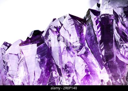 amethyst Druse isoliert auf weißem Hintergrund. Texturhintergrund für Makrodetails. Nahaufnahme von rohem, unpoliertem Halbedelstein Stockfoto