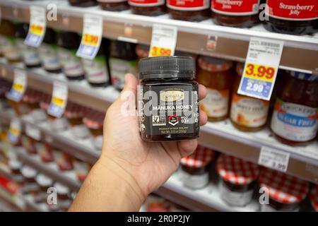 Los Angeles, Kalifornien, Vereinigte Staaten - 10-25-2021: Eine Hand, die einen Container mit Honig von Comvita Manuka hält. Stockfoto