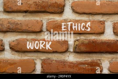 Symbol für Arbeitsethik. Konzeptbegriffe funktionieren ethisch auf wunderschönen roten braunen Ziegelwänden auf wunderschönen roten braunen Ziegelwänden Hintergrund. Geschäfts- und Arbeitsethik Stockfoto