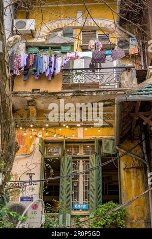 Gewaschene Kleidung hing zum Trocknen vor dem Balkon eines Stadthauses in der Altstadt von Hanoi, Vietnam. Stockfoto