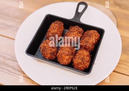 Ration typischer spanischer Kroketten gefüllt mit Hühnchen und Meeresfrüchten Stockfoto