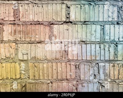 Rote geriffelte Ziegelwand mit weißer abblätternder Farbe. Hintergrundbild mit Mauerwerk aus Ziegelstein mit gerillter Textur. Betonblockwand mit Vinta Stockfoto