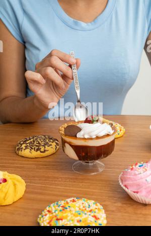 Exquisites süßes Dessert dekoriert mit verschiedenen Belägen, Eis, Sahne, Müsli und Kekse, Tapete im Studio mit süßen Speisen, Gebäck Stockfoto