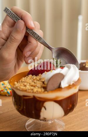 Süßes Dessert mit verschiedenen Belägen, Eis, Sahne, Müsli, Erdbeeren und Keksen, Tapete im Food Studio, Gebäck Stockfoto