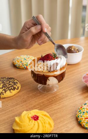 eine tasse Eiscreme mit Sahne, Müsli und Keksen, Tapete im Studio mit süßen Speisen, köstliches Gourmet-Gebäck, Desserts Stockfoto