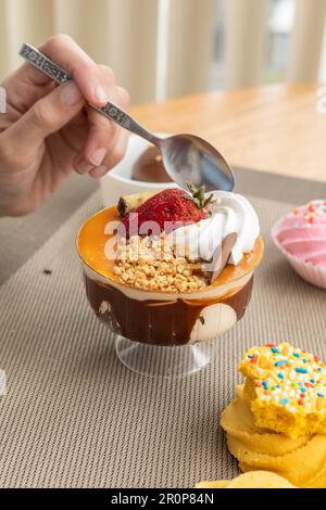 Tapete des Restaurants mit einer Tasse Eis mit Sahne, dekoriert mit Keksen, Tapete im Studio mit süßen Speisen, köstliches Gourmet-Gebäck Stockfoto