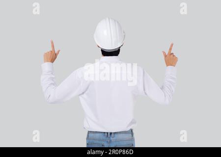 Porträt junger asiatischer Mann ist Ingenieur, der einen Helm trägt, der steht, und mit einem selbstbewussten isolierten weißen Hintergrund, männlich ist Architekt oder Bauunternehmer, der präsentiert Stockfoto