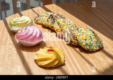 studio und süße Speisen auf einem Tisch, Details von Keksen mit Belag, Tapete mit exquisiten Desserts Stockfoto