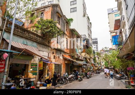 Eine typische Straßenszene in der Innenstadt von Hanoi mit einer zufälligen Ansammlung von Gebäuden in verschiedenen Stilrichtungen, die sich in verschiedenen Reparaturzuständen befinden. Vietnam. Stockfoto