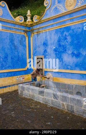 Ein Einheimischer, der Plastikflaschen am Sabuga-Brunnen in Sintra füllt Stockfoto