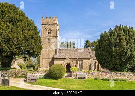 Die Kirche St. George im Cotswold-Dorf Hampnett, Gloucestershire UK, dekoriert mit Flaggen, um die Krönung von König Karl III. Zu feiern Stockfoto