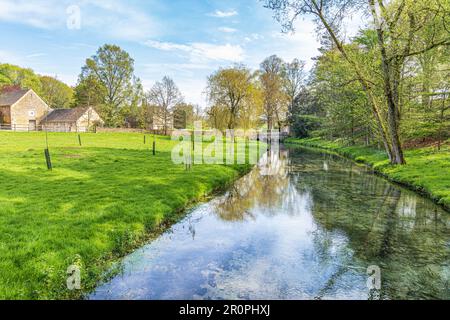 Das Sherborne Brook in Richtung Haycroft Farm & Haycroft House in der Nähe des Dorfes Cotswold Sherborne, Gloucestershire, Großbritannien Stockfoto