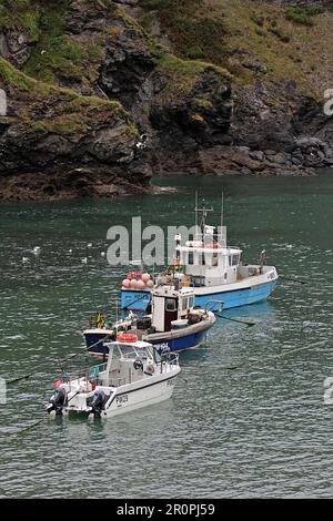 PORT ISAAC, CORNWALL, Großbritannien - 7. JULI 2017 Fischer und Fischerboote im Hafen an einem klaren blauen Tag Stockfoto