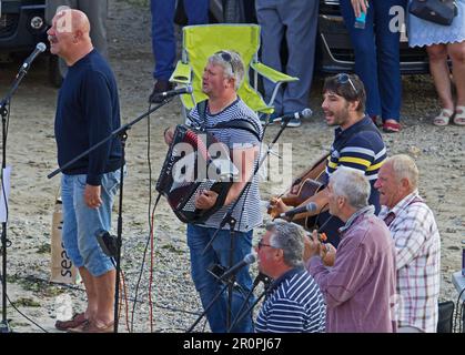 PORT ISSAC, CORNWALL, Großbritannien - 6. JULI 2018 Fisherman's Friends kostenlose Vorstellung am Strand im Hafen Stockfoto