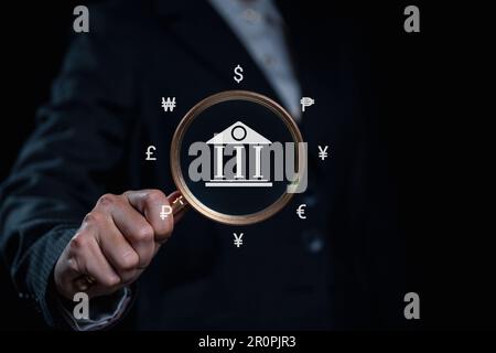 Eine Geschäftsfrau, die mit Online-Banking und -Bezahlung eine Lupe hält Stockfoto