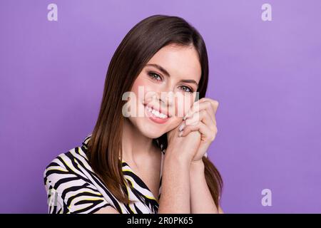 Foto einer friedlichen, netten Dame mit gefalteten Armen unter Wangenstrahlen und Lächeln auf violettem Hintergrund Stockfoto