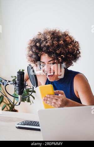 Afrikanische Gastgeberin nimmt Podcast mit Handy im Heimstudio auf - Business, Podcaster-Technologie-Konzept Stockfoto