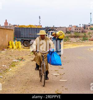 AIT Ourir, Marokko - 04. April 2023: Lokale Marktszene mit Einheimischen, die Waren transportieren, in der Stadt Ait Ourir, Marokko Stockfoto