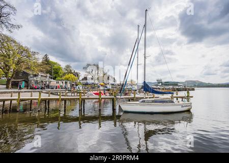 Yachten und Vergnügungsboote belegen die Küste und die Jetys am Waterhead am Ambleside-Abschnitt des Lake Windermere im Mai 2023. Stockfoto