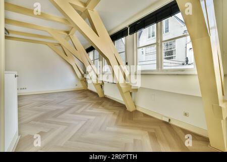 Ein leerer Raum mit Holzfußboden und Holzbalken an der Decke auf diesem Foto wird von innen aufgenommen Stockfoto