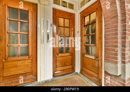 Zwei Holztüren vor einem Ziegelgebäude mit Glaseinsätzen an der Tür und Seitenfenstern Stockfoto