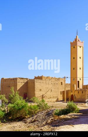 Blick auf ein typisches Schlammhaus-Dorf mit Häusern, Moschee und Minarett in der Sahara, Marokko Stockfoto