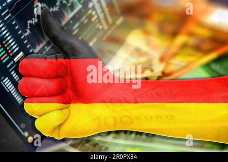 Wirtschaftsdiagramm: Daumen hoch mit der deutschen Flagge, den Börsenindikatoren und den Euro-Bargeld-Banknoten (Geld, Inflation, Erfolg, Märkte, Finanzen, Unternehmen) Stockfoto