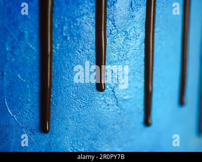 Makro mit blauem Frostguss und dunklem Schokoladenglasur und gemischten Süßigkeiten, isoliert auf weißem Hintergrund zum Feiern Stockfoto