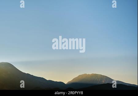 Die Sonne bei Sonnenaufgang erleuchtet die Berge, früh morgens in den Bergen an der mittelmeerküste, Urlaubsidee, Hintergrund für A s Stockfoto