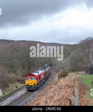 DB Cargo Rail-Diesellokomotive der Klasse 66, die Bedlinog auf der steilen Strecke Cwmbargoed mit einer Zugladung walisischer Kohle aus Ffos-Y-Fran passiert Stockfoto