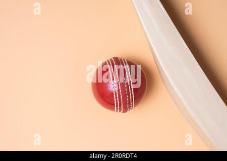 Cricketschläger und rote Bälle auf grünem Hintergrund. Horizontales Sportposter, Grußkarten, Kopfzeilen, Website und App Stockfoto