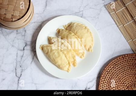 Pastel Goreng ist ein beliebtes Gebäck in Indonesien. Frisch zubereitetes rohes Pastell gefüllt mit Gemüse und Hühnerfleisch Stockfoto