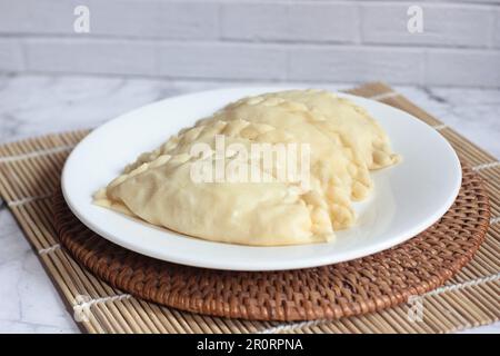 Pastel Goreng ist ein beliebtes Gebäck in Indonesien. Frisch zubereitetes rohes Pastell gefüllt mit Gemüse und Hühnerfleisch Stockfoto