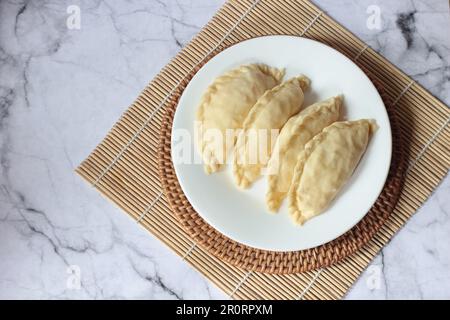 Pastel Goreng ist ein beliebtes Gebäck in Indonesien. Frisch zubereitetes rohes Pastell gefüllt mit Gemüse und Hühnerfleisch Stockfoto