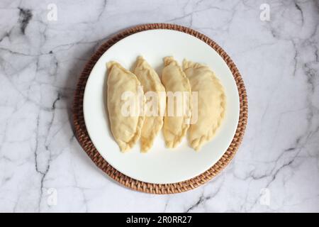 Pastel Goreng ist ein beliebtes Gebäck in Indonesien. Frisch zubereitetes rohes Pastell gefüllt mit Gemüse und Hühnerfleisch Stockfoto