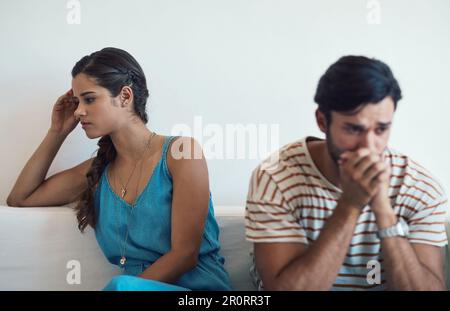 Wie konnten wir so weit auseinander driften? Ein junges Paar, das sich streitet, während es zu Hause auf der Couch sitzt. Stockfoto