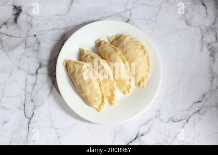 Pastel Goreng ist ein beliebtes Gebäck in Indonesien. Frisch zubereitetes rohes Pastell gefüllt mit Gemüse und Hühnerfleisch Stockfoto