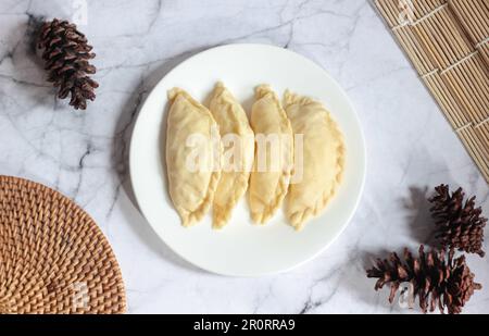 Pastel Goreng ist ein beliebtes Gebäck in Indonesien. Frisch zubereitetes rohes Pastell gefüllt mit Gemüse und Hühnerfleisch Stockfoto