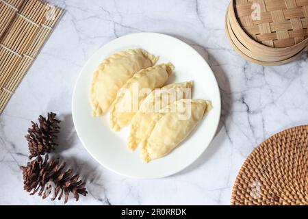 Pastel Goreng ist ein beliebtes Gebäck in Indonesien. Frisch zubereitetes rohes Pastell gefüllt mit Gemüse und Hühnerfleisch Stockfoto