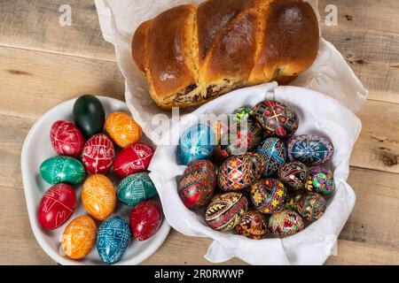 Frisch gebackene rumänische Kuchen und handbemalte Ostereier. „Cozonac“ oder „cozonaci“ wird aus süßem Hefeteig hergestellt, der zur Herstellung von traditionellem holi verwendet wird Stockfoto