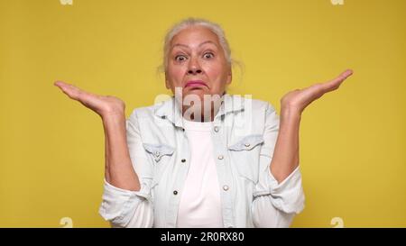 Die ältere europäische Frau zuckt mit den Schultern vor Verwirrung Stockfoto