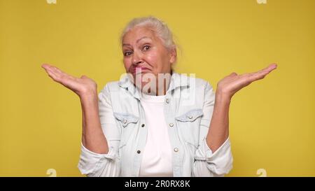 Die ältere europäische Frau zuckt mit den Schultern vor Verwirrung Stockfoto