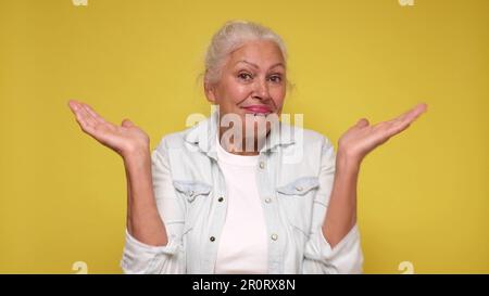 Die ältere europäische Frau zuckt verwirrt mit den Schultern Stockfoto