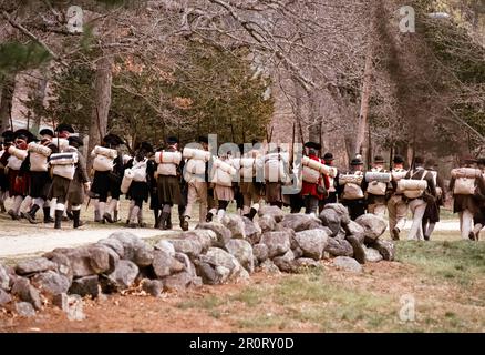 Lexington, Massachusetts, USA - April 2023: Im Minuteman National Histori stoßen koloniale und britische Truppen auf Musketen, die auf der Battle Road schießen Stockfoto