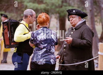 Lexington, Massachusetts, USA - April 2023 – zwei Besucher halten an der Battle Road im Minuteman Natio, um mit einem Schauspieler aus der Kolonialzeit zu sprechen Stockfoto