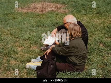 Lexington, Massachusetts, USA - April 2023 - Während der Schlacht von liegt Ein Paar vor Ort und liest eine Karte des Minuteman National Historical Park Stockfoto