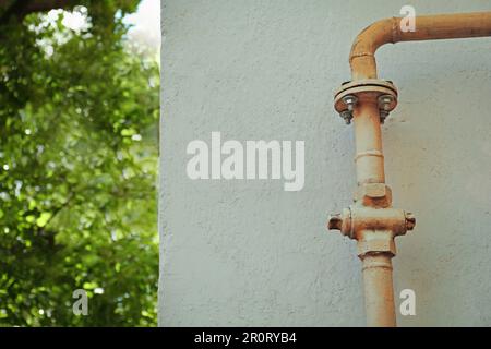 Gelbes Metallrohr in der Nähe der Wand im Freien, Platz für Text Stockfoto