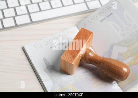 Ukraine, Lemberg - 6. September 2022: Pass- und Visummarke auf Holztisch, Nahaufnahme Stockfoto